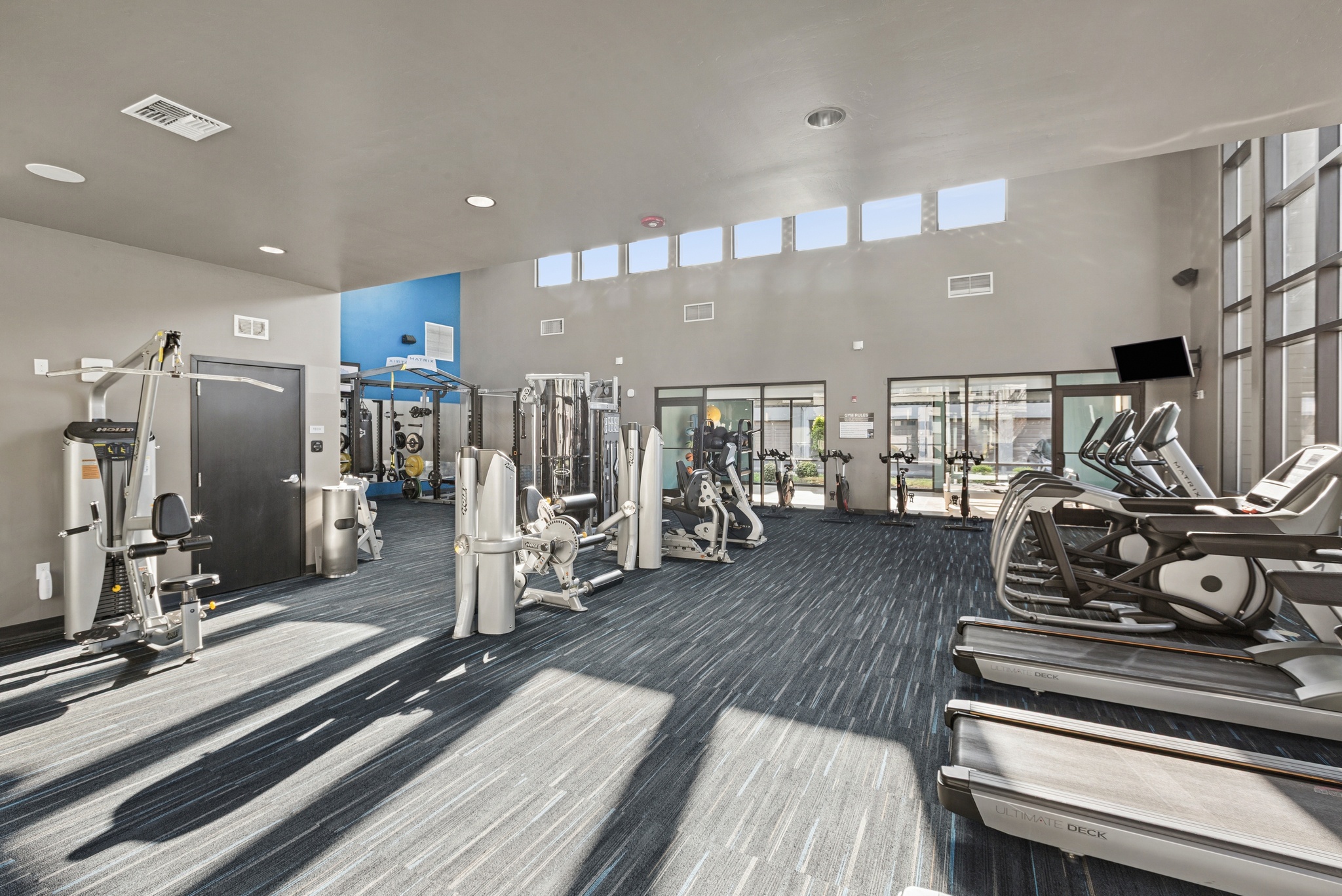 Aspire Apartments Tracy CA amenities gym with treadmills, weights, and other exercise equipment.