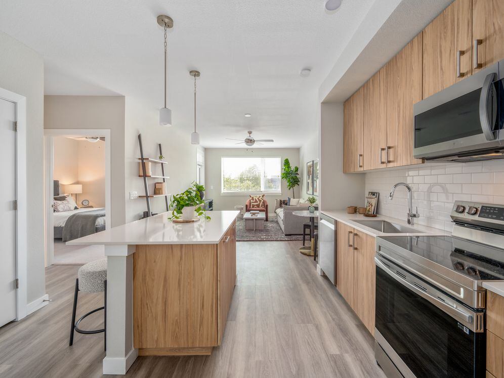 Kitchen with oak cabinetry, stainless-steel appliances, pendant lighting, hard-surface flooring and granite countertops