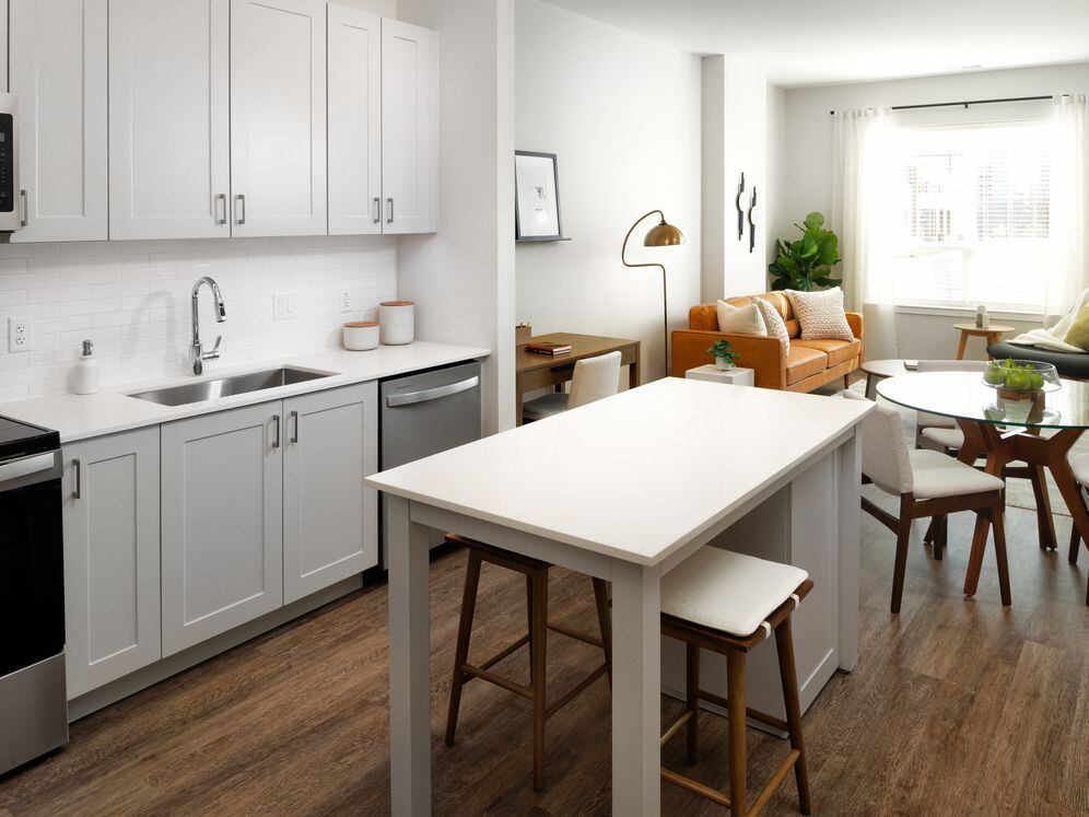 New West Phase apartments - Finish Package III Kitchen with stainless steel appliances, white quartz countertops, grey cabinetry, and hard surface flooring throughout