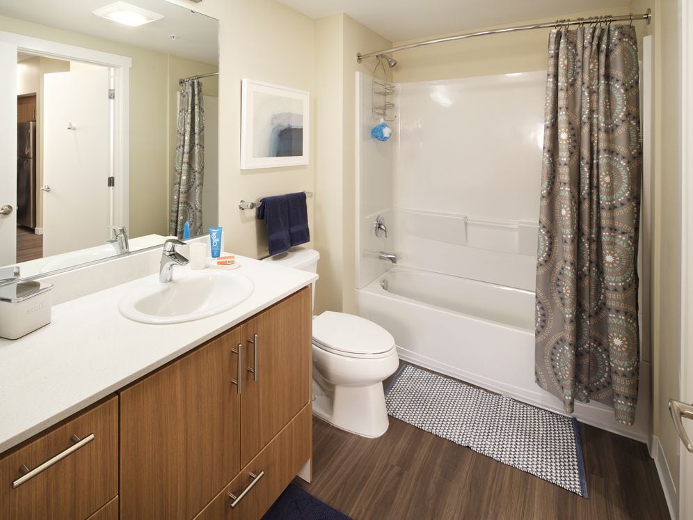 Phase I - Scheme B Kitchen with oak cabinetry, stainless appliances, white quartz countertops, and hard surface flooring