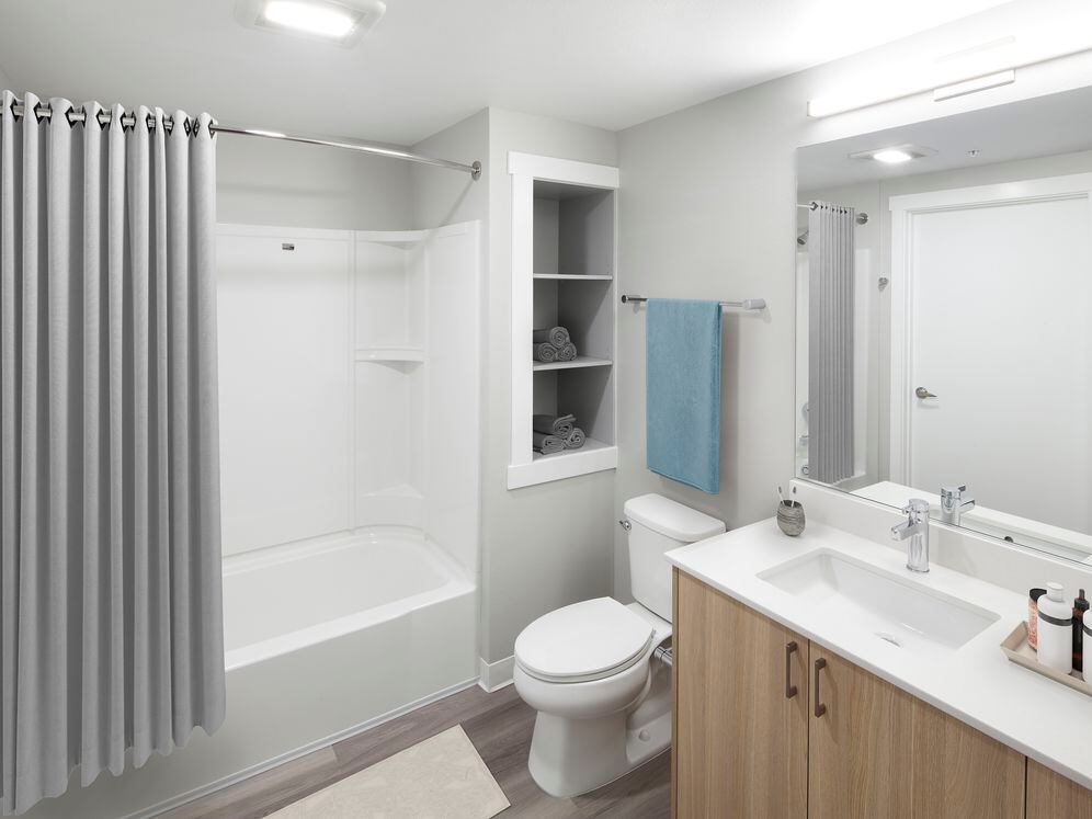 Phase II - Scheme D Bath with oak cabinetry, white quartz countertop, and hard surface flooring