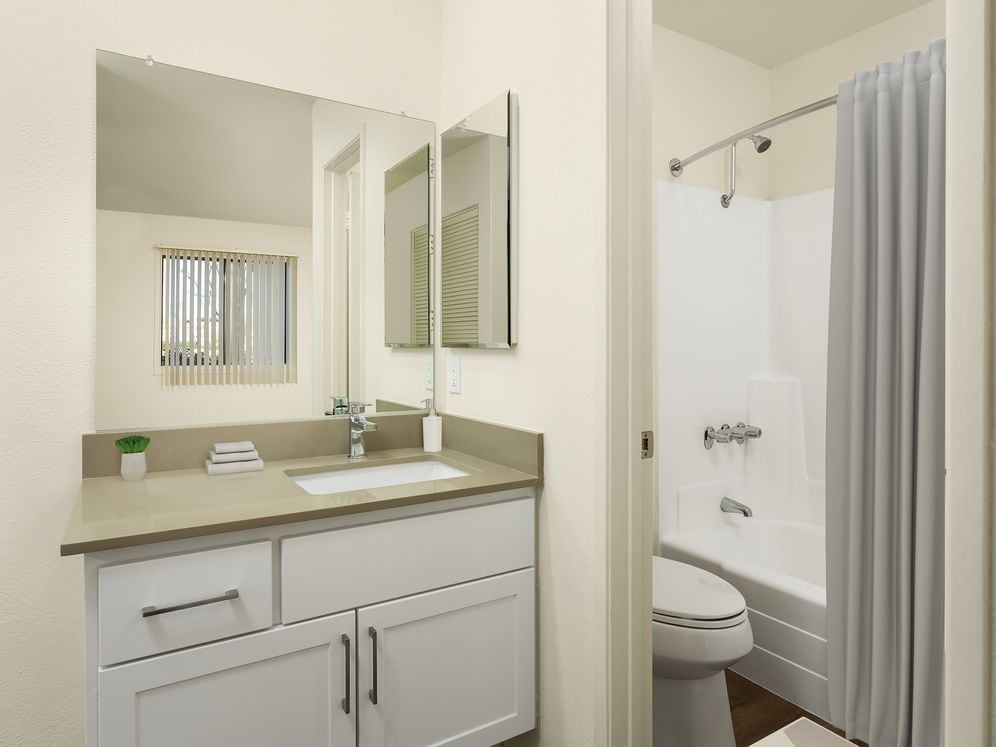 Renovated I bath with grey quartz countertops, white cabinetry, and hard surface flooring