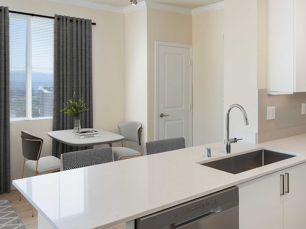 Renovated Package I kitchen and dining area featuring white cabinetry, white quartz countertops, stainless steel appliances, and hard surface flooring