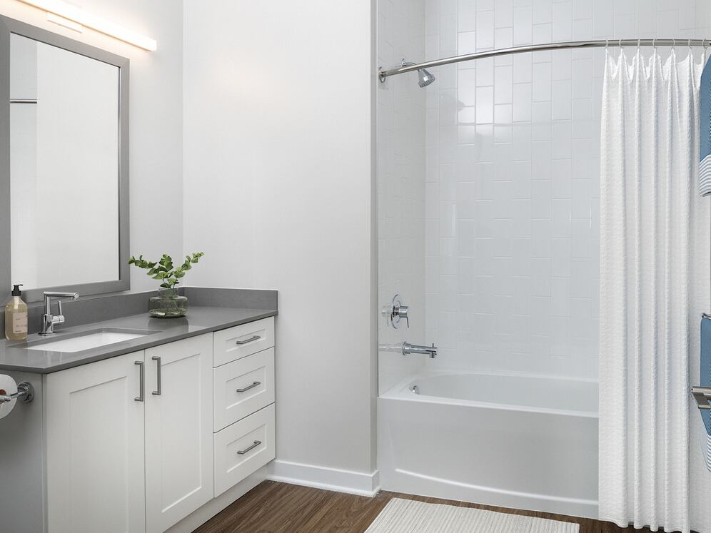 Upgrade Collection Guest bath with white cabinetry, grey quartz countertop, and hard-surface vinyl plank flooring