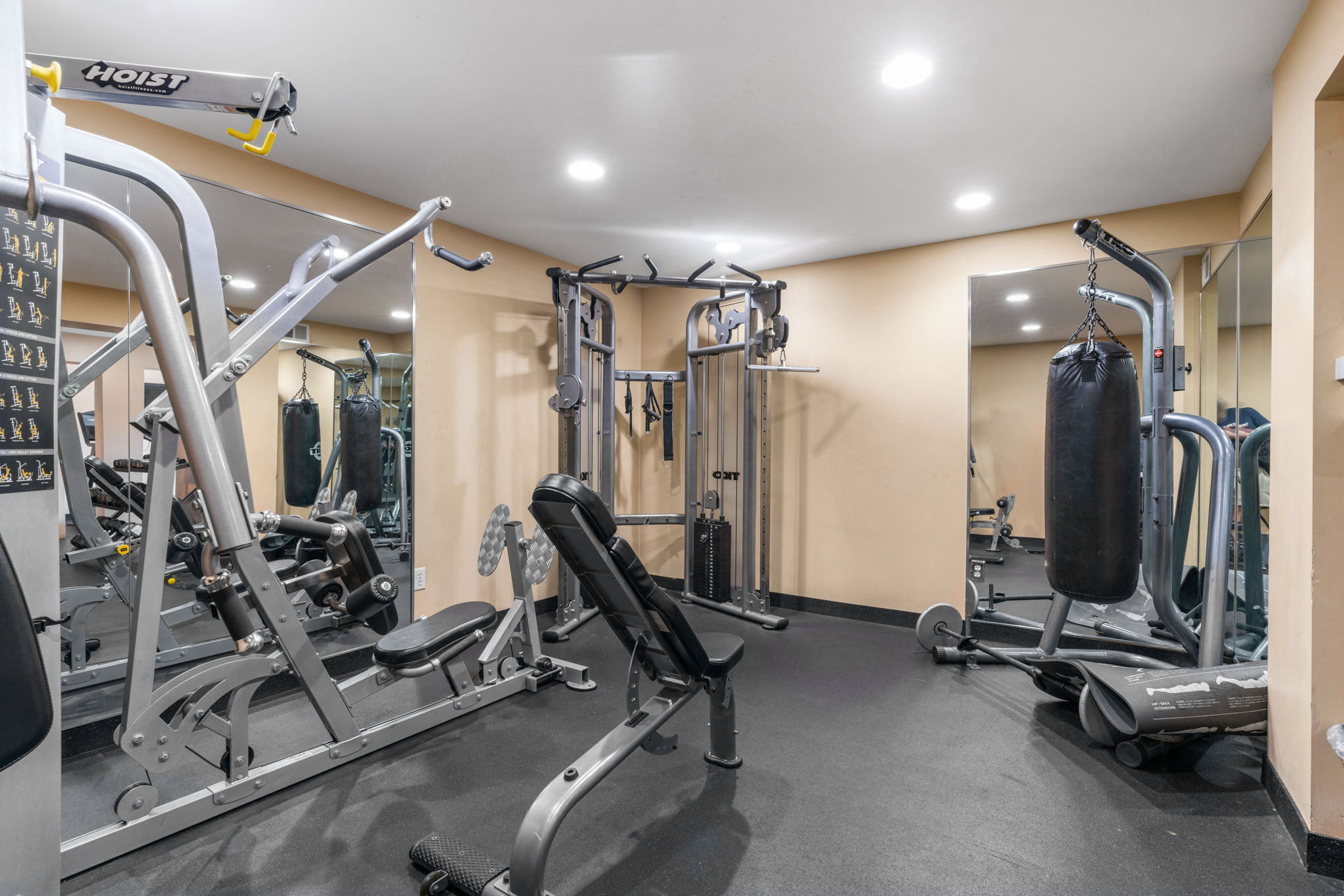 A gym with a variety of equipment including treadmills, weights, and exercise machines.