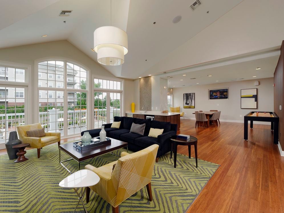 Resident lounge with patio, kitchenette, common area seating and shuffleboard table