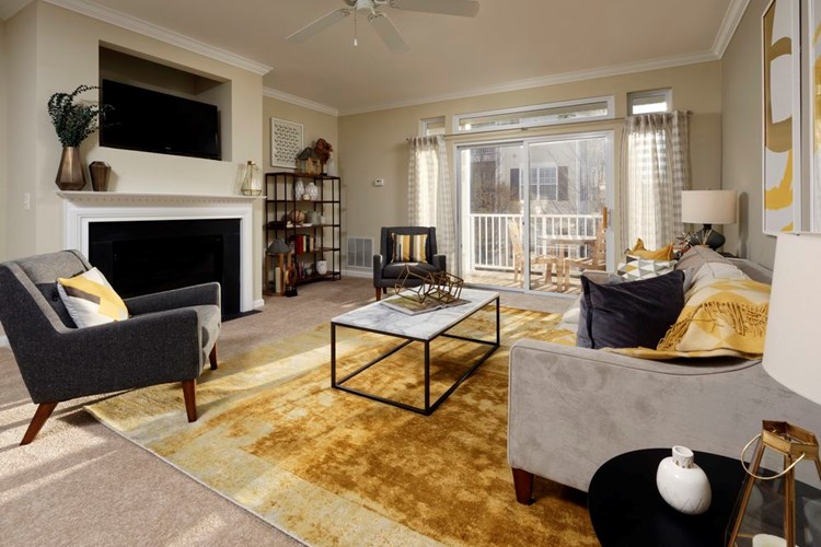 Classic Package I living area with fireplace, ceiling fan and carpeted flooring