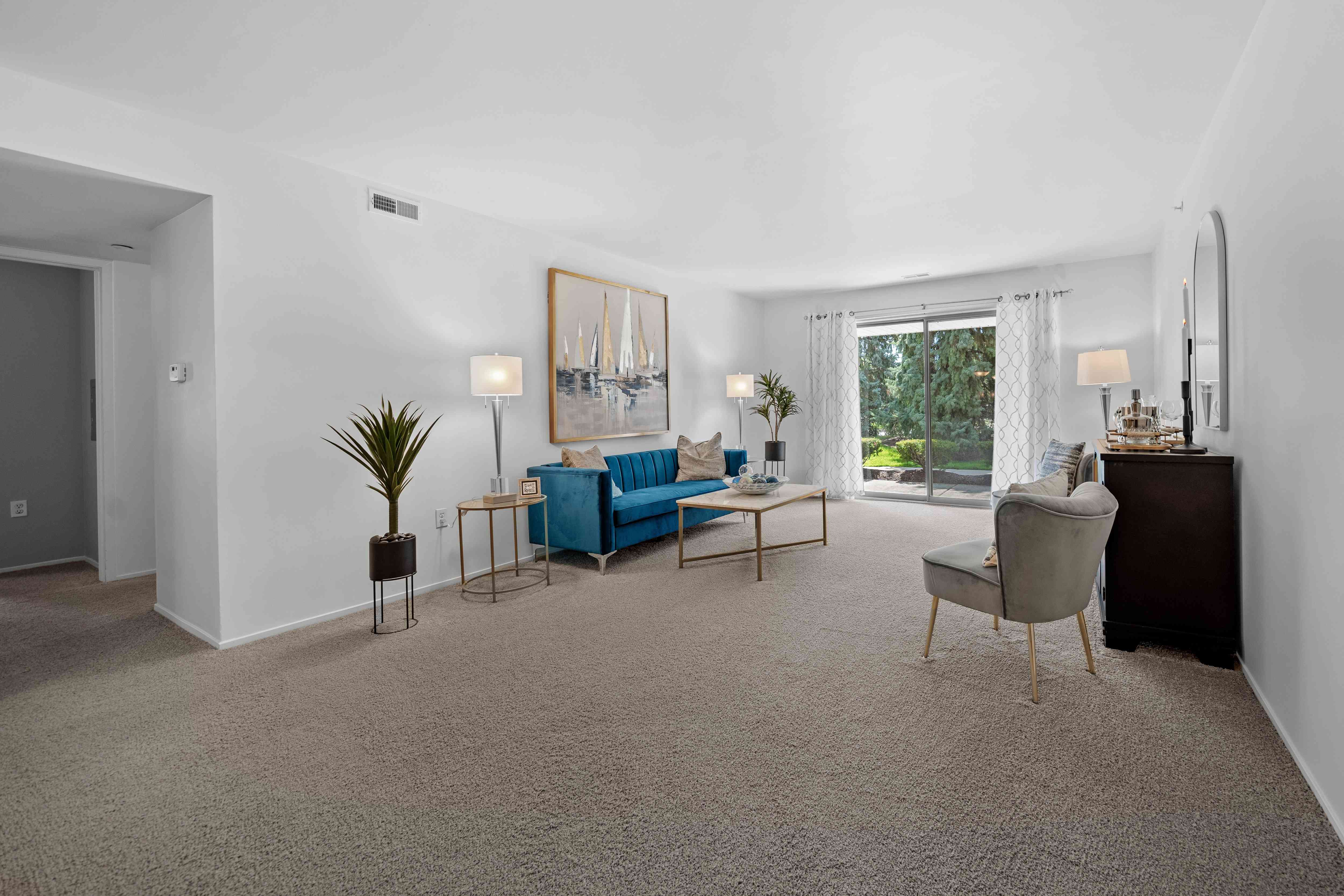 Spacious Living room with patio at Prentiss Pointe Apartments in Harrison Township