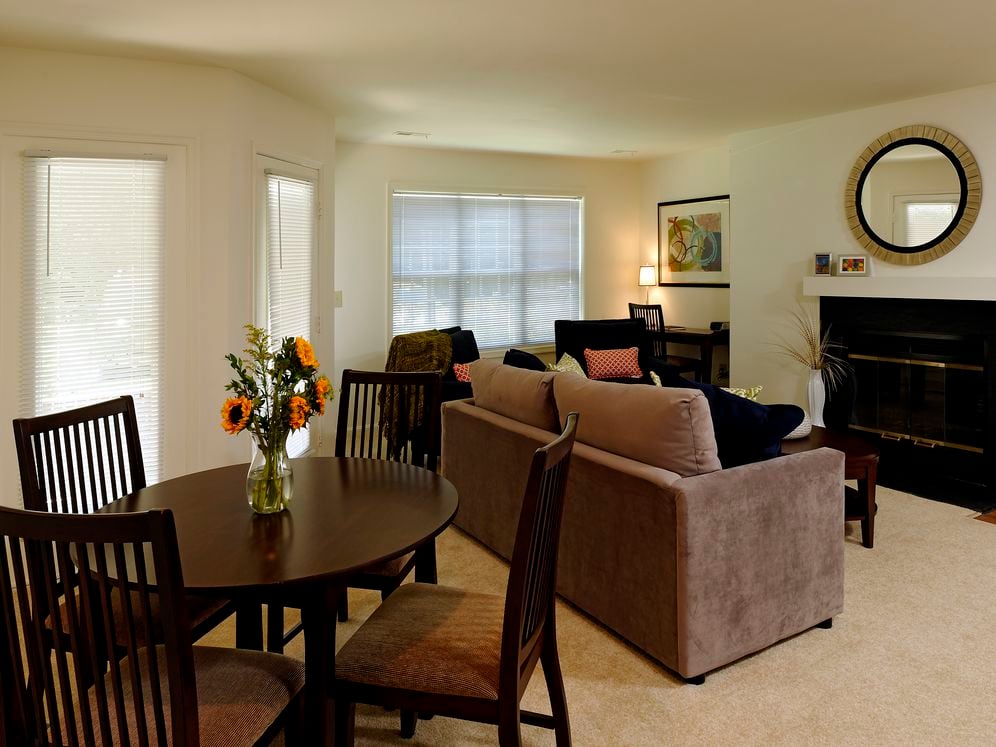 Carpeted dining and living area with fireplace