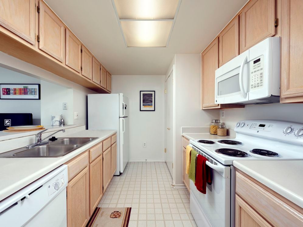 Classic Package I kitchen with white countertops, oak cabinetry, and white appliances