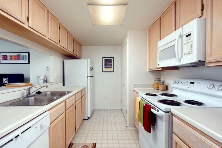 Classic Package I kitchen with white countertops, oak cabinetry, and white appliances