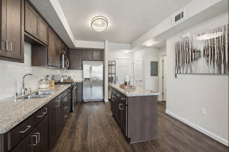 Aspire Apartments Tracy CA A modern kitchen with dark wood cabinets and stainless steel appliances.