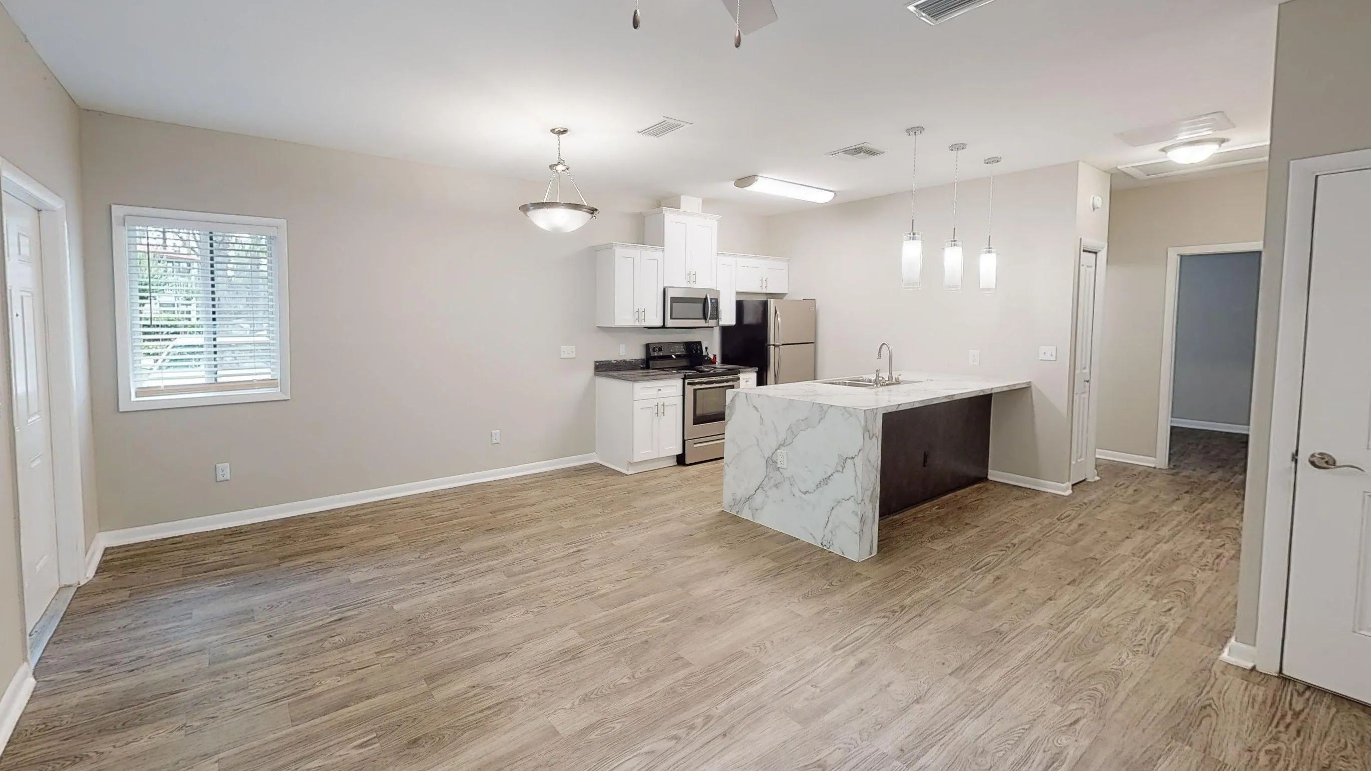 Enjoy the comfort of an open-concept kitchen and dining area featuring a breakfast bar, modern cabinetry, stainless steel appliances, and plenty of room to gather with family and friends.