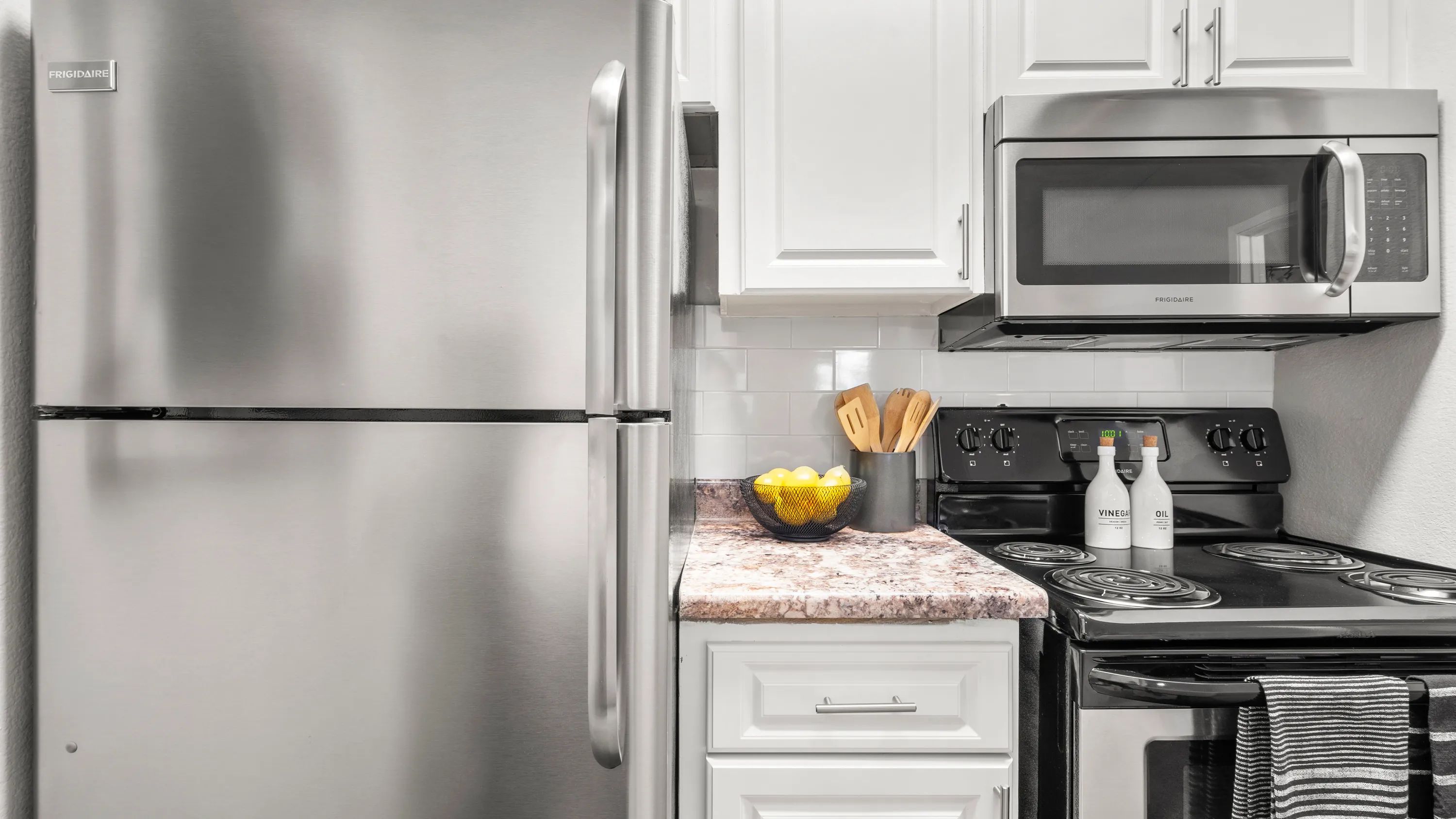 Our newly remodeled kitchens impress with timeless white cabinetry, elegant granite-style countertops, and a prominent white subway tile backsplash. 