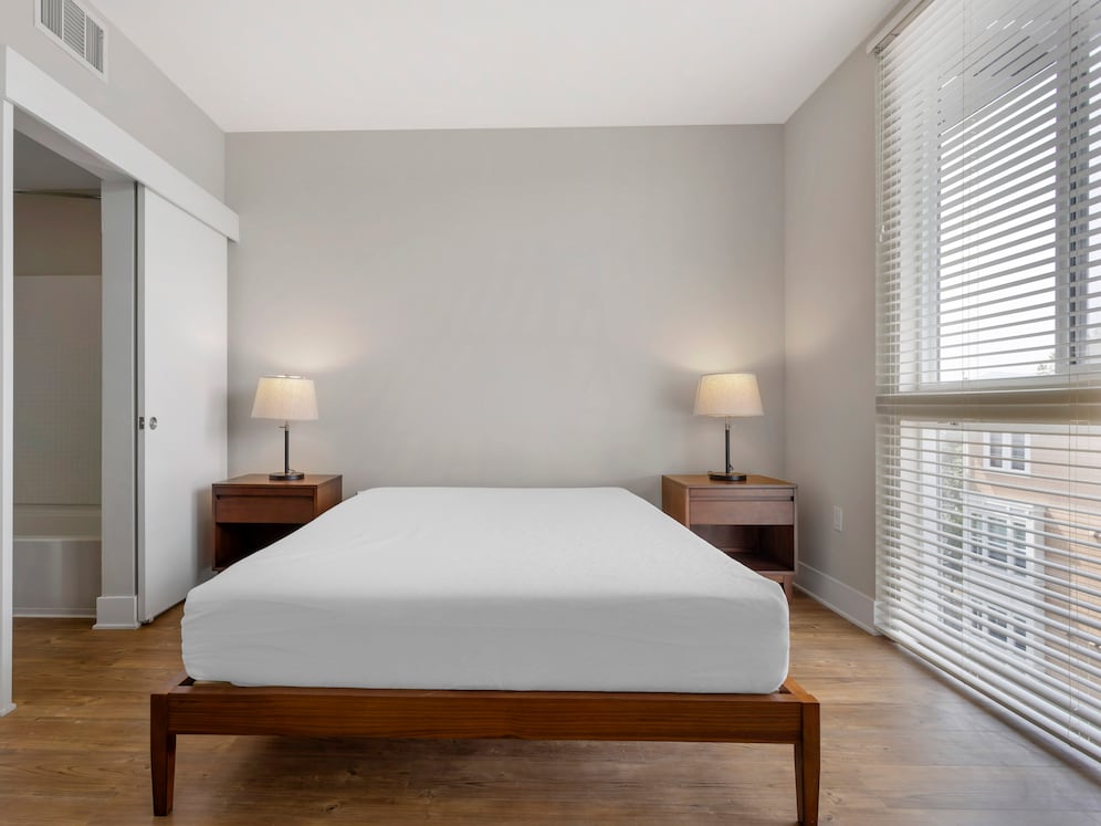 Furnished+ apartment homes feature queen bed with mattress, dresser, nightstands, and lamps (Representative Image – exact items and style of furnishings may vary)