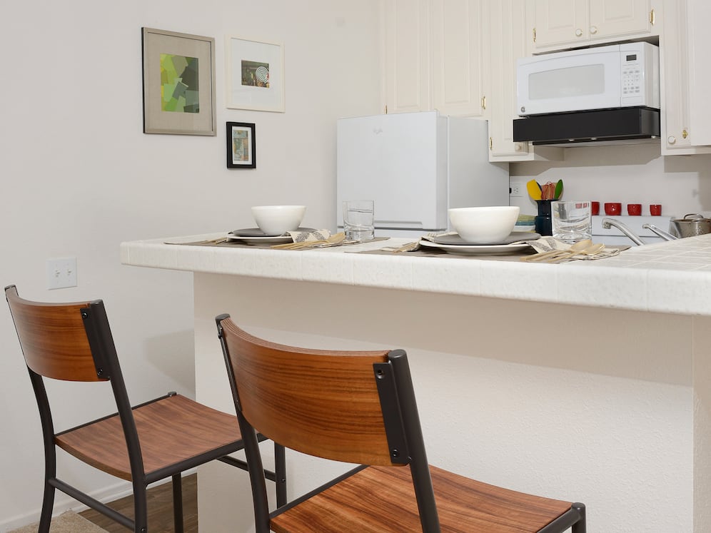 Classic Package I kitchen with white appliances, white tile countertops, white cabinetry, and hard surface flooring