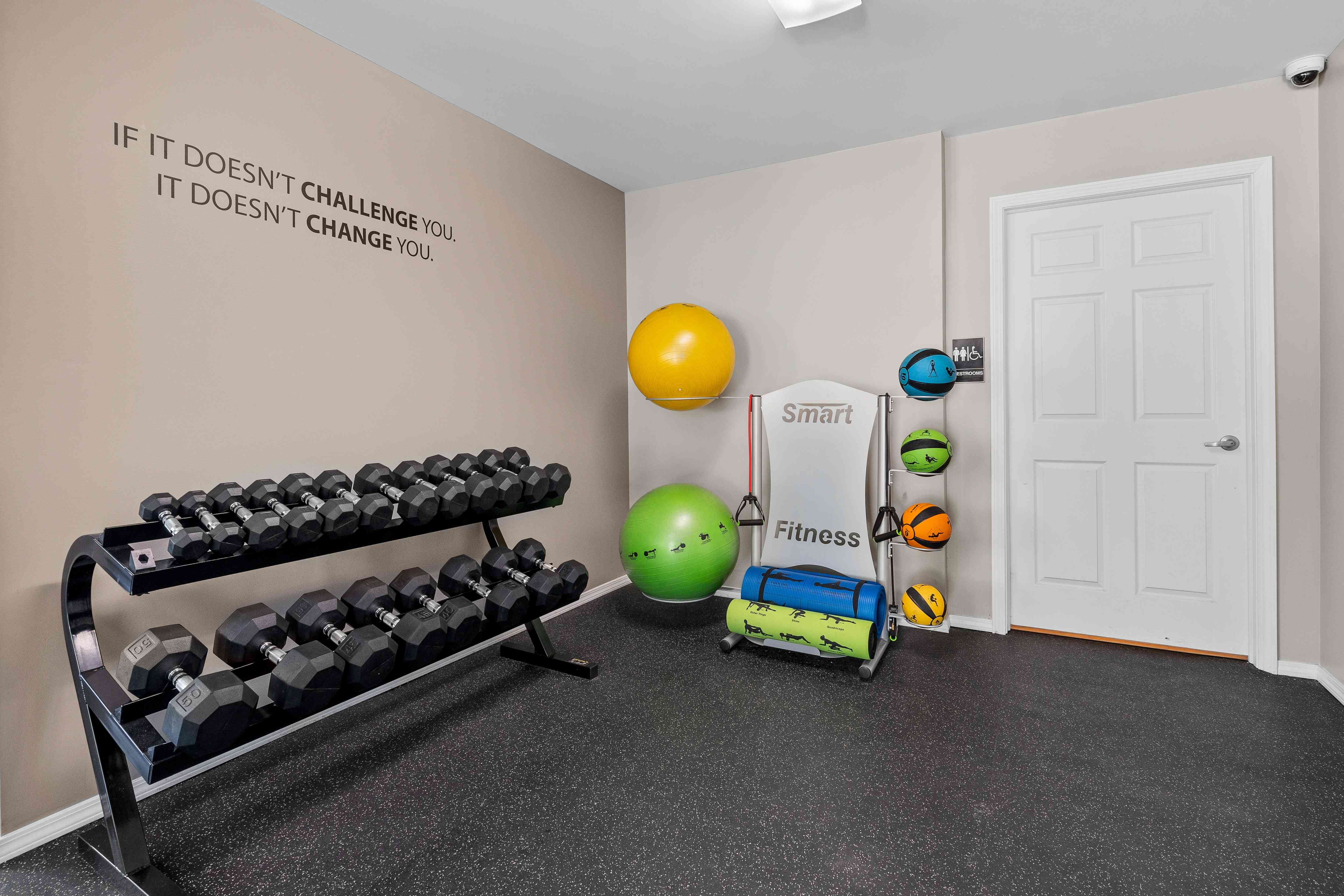 24-hour fitness center at cardio machines and weights at Woodland Villa Apartments in Westland, MI.
