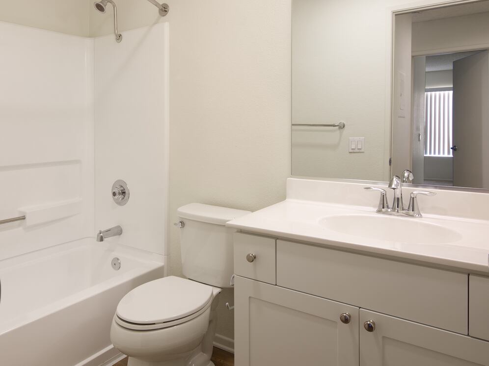 Renovated Package I bath with white cabinetry and hard-surface flooring