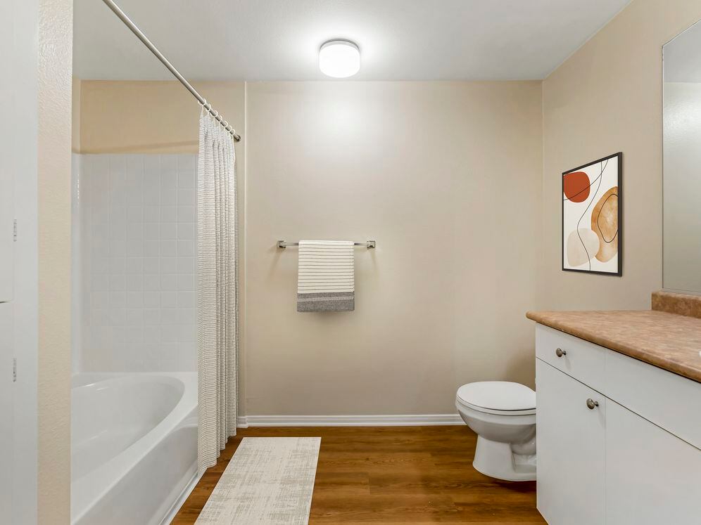 Classic Package II bath with neutral laminate countertop, white cabinetry, and upgraded hard surface flooring