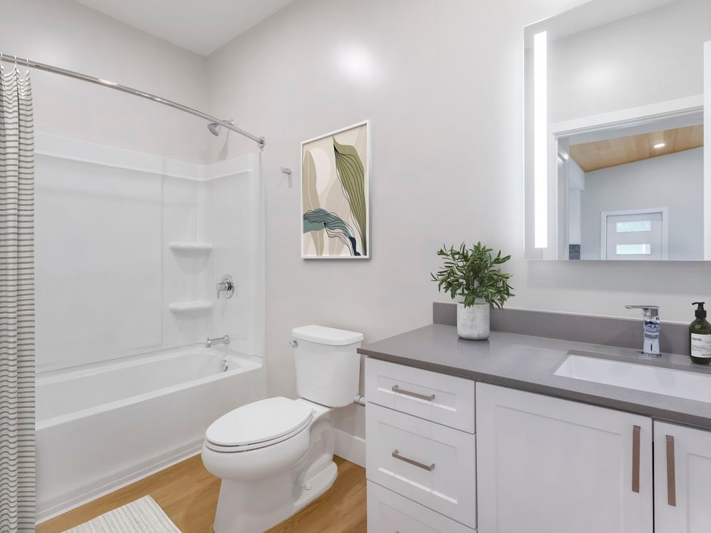 Freestanding Home bath with white cabinetry, grey quartz countertops, and hard surface flooring