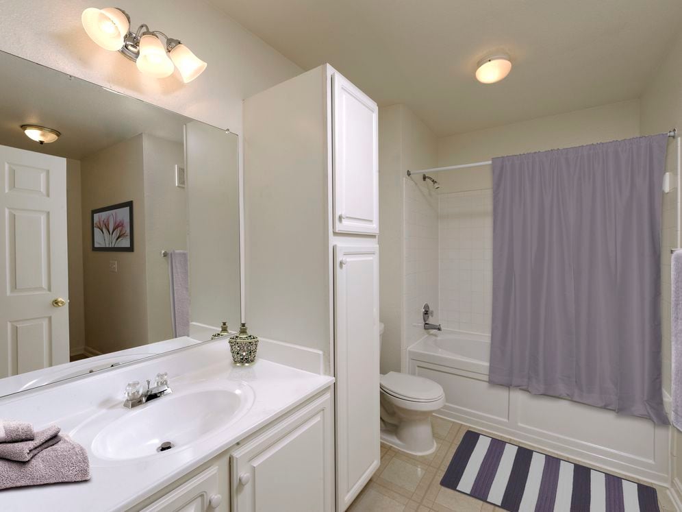 Classic Package bath white white cabinetry, white laminate countertops, and vinyl tile flooring