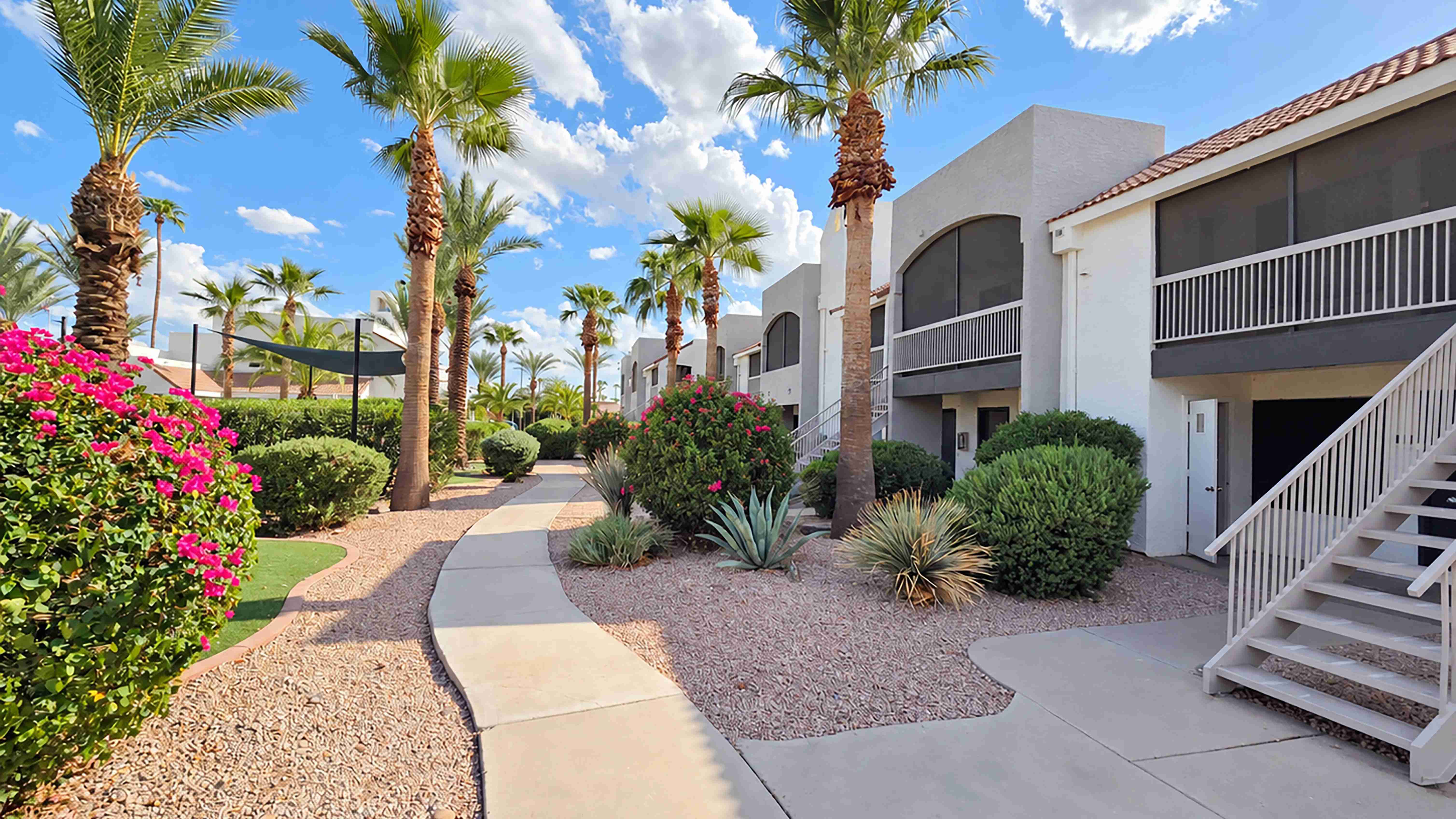 Winding pathways, mature palm trees, colorful blooms, and lush greenery create a scenic backdrop for everyday apartment living at Level 550.