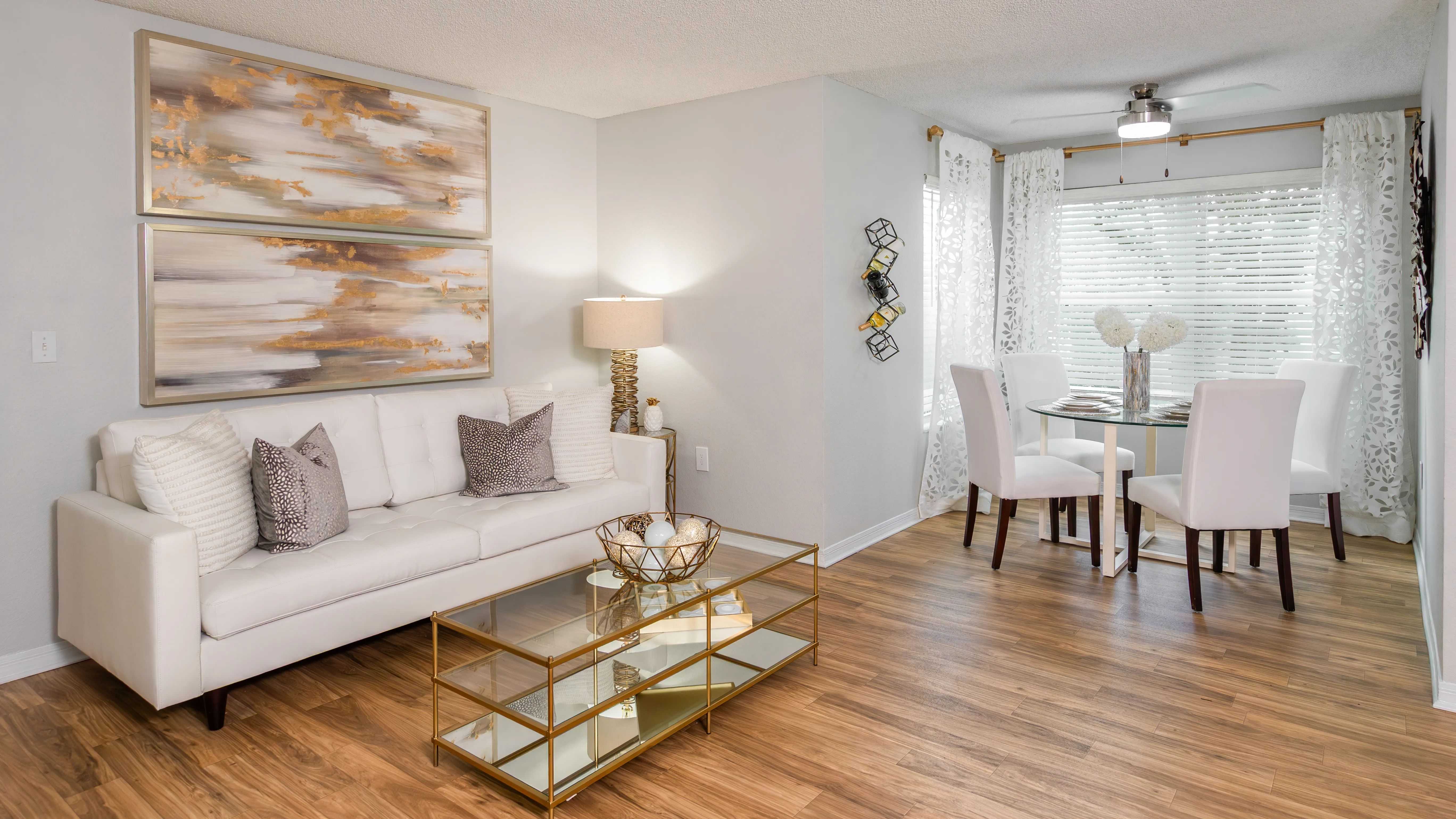 Bright, open-concept living and dining area featuring wood-style flooring and plenty of natural light—perfect for entertaining or relaxing.