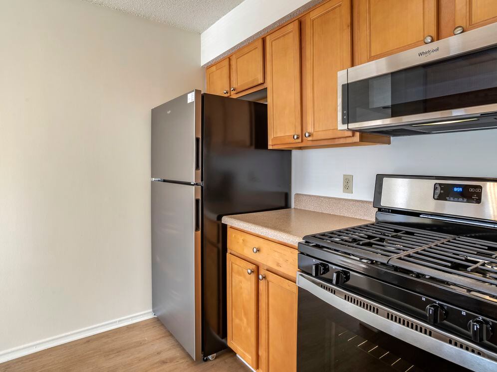 Renovated Package I kitchen with stainless steel appliances, laminate countertops, oak cabinetry, and hard surface flooring