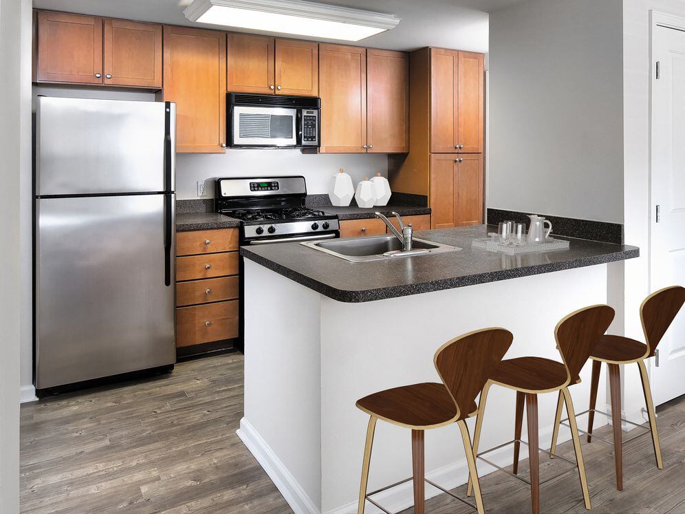 Finish Package I kitchen with oak cabinetry, black laminate countertops, stainless steel appliances, and hard surface flooring or tile