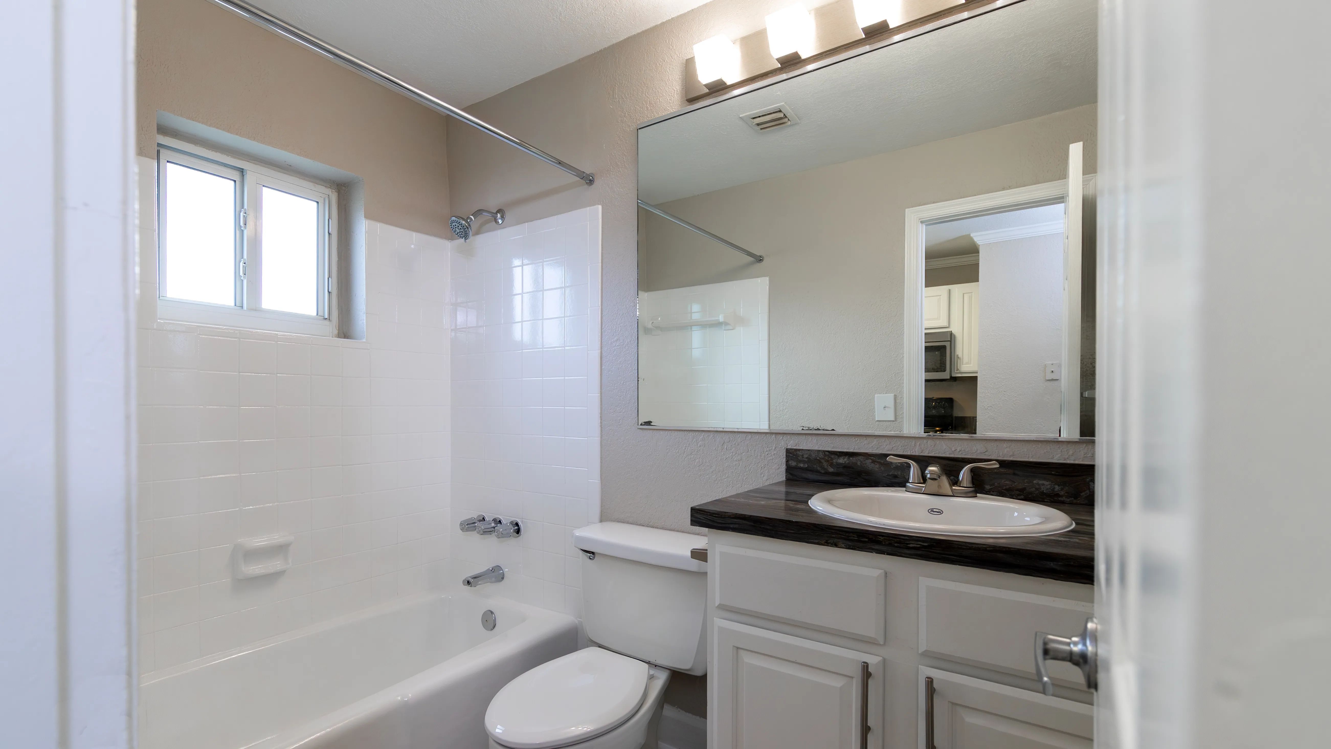  Enjoy selfcare in a space that echoes the kitchen's charm with black fusion counter tops and white shaker cabinetry. 