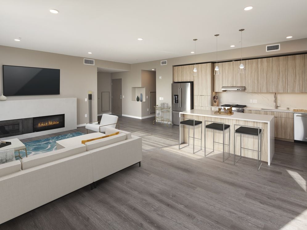 Signature Collection penthouse kitchen, dining area, and living room with fireplace and hard surface flooring.