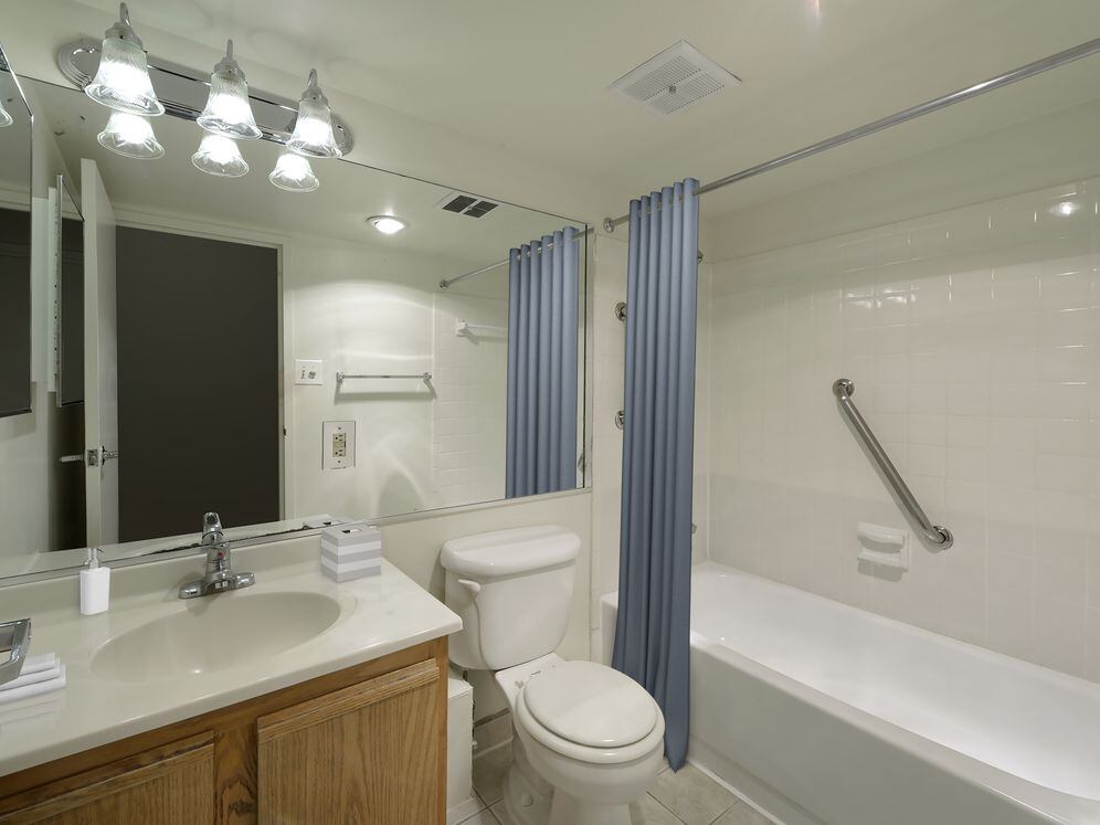 Finish Package I bathroom with white countertop, tile flooring and shower with tile backsplash