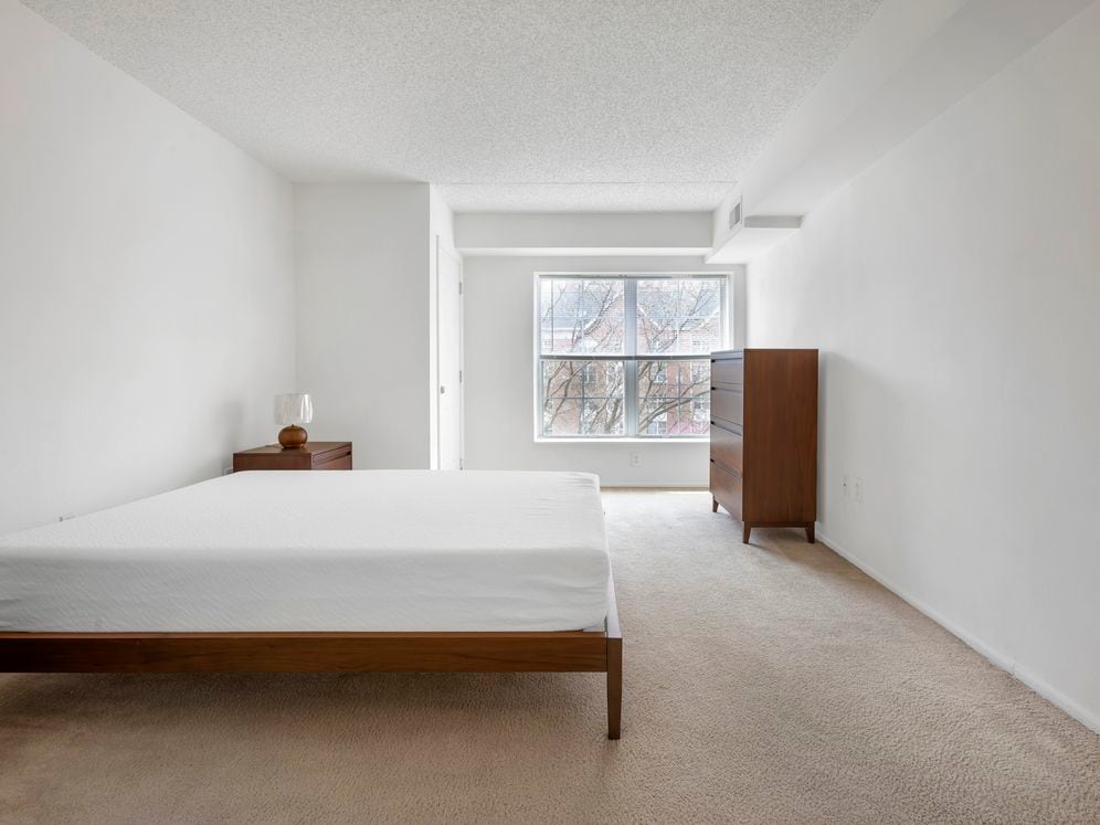 Furnished+ apartment homes feature queen bed with mattress, dresser, nightstands, and lamps (Representative Image – exact items and style of furnishings may vary)