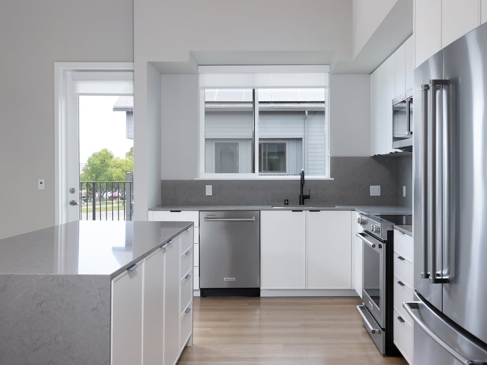 Signature Collection II Apartment with kitchen featuring white cabinetry, grey quartz backsplash and countertop, upgraded stainless steel appliances, and more