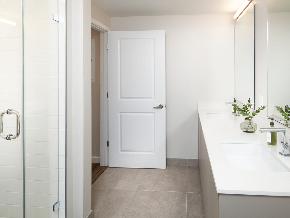 Upgrade Collection I One-bedroom primary bath with double-sink vanity, white quartz countertops, and standing shower