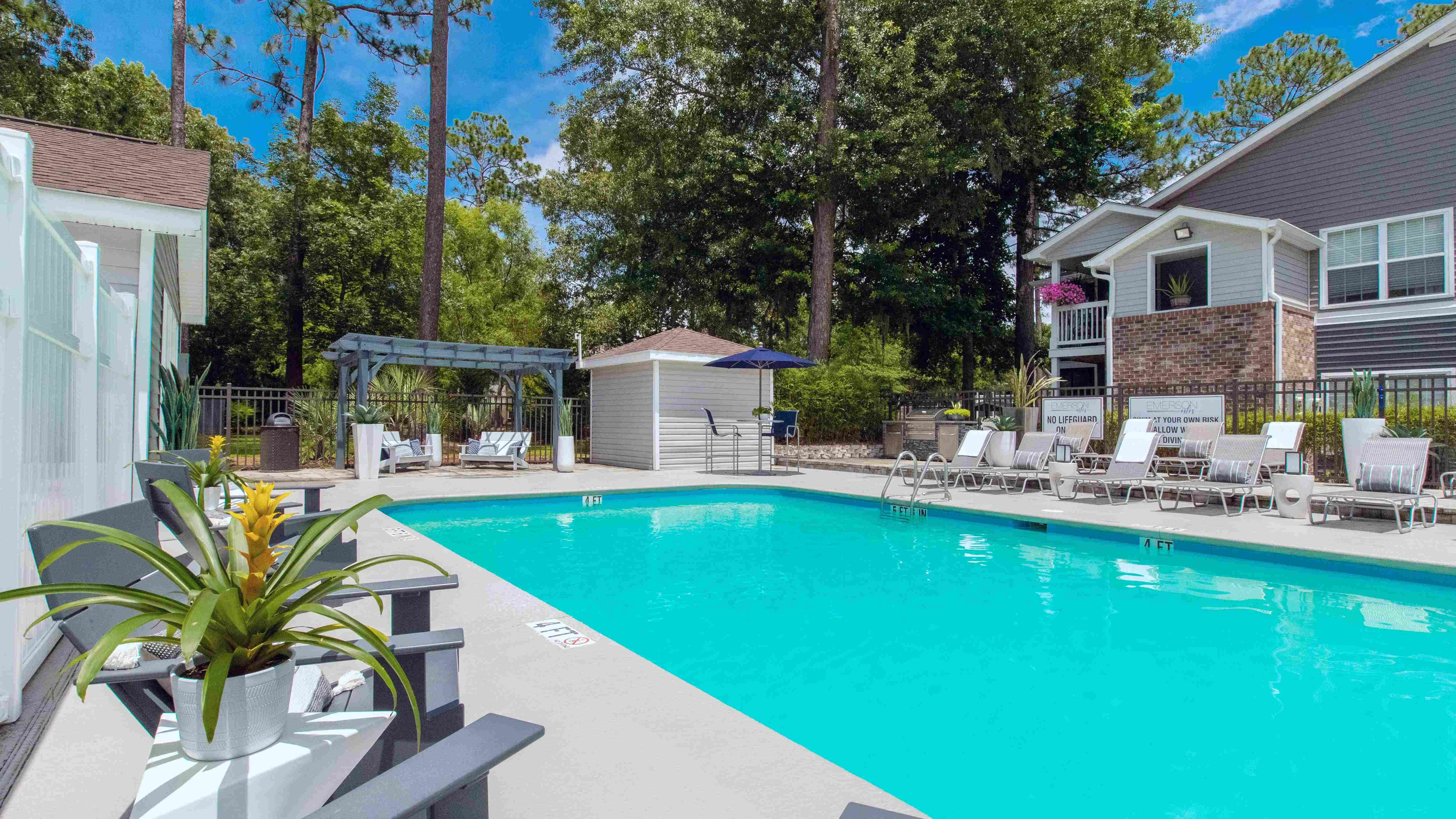 Our second community pool is a quaint, tranquil oasis featuring ample loungers and shaded tables with umbrellas on the pool deck.