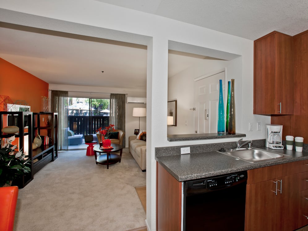 Classic Package kitchen with black appliances, dark grey laminate countertops, and cherry cabinetry