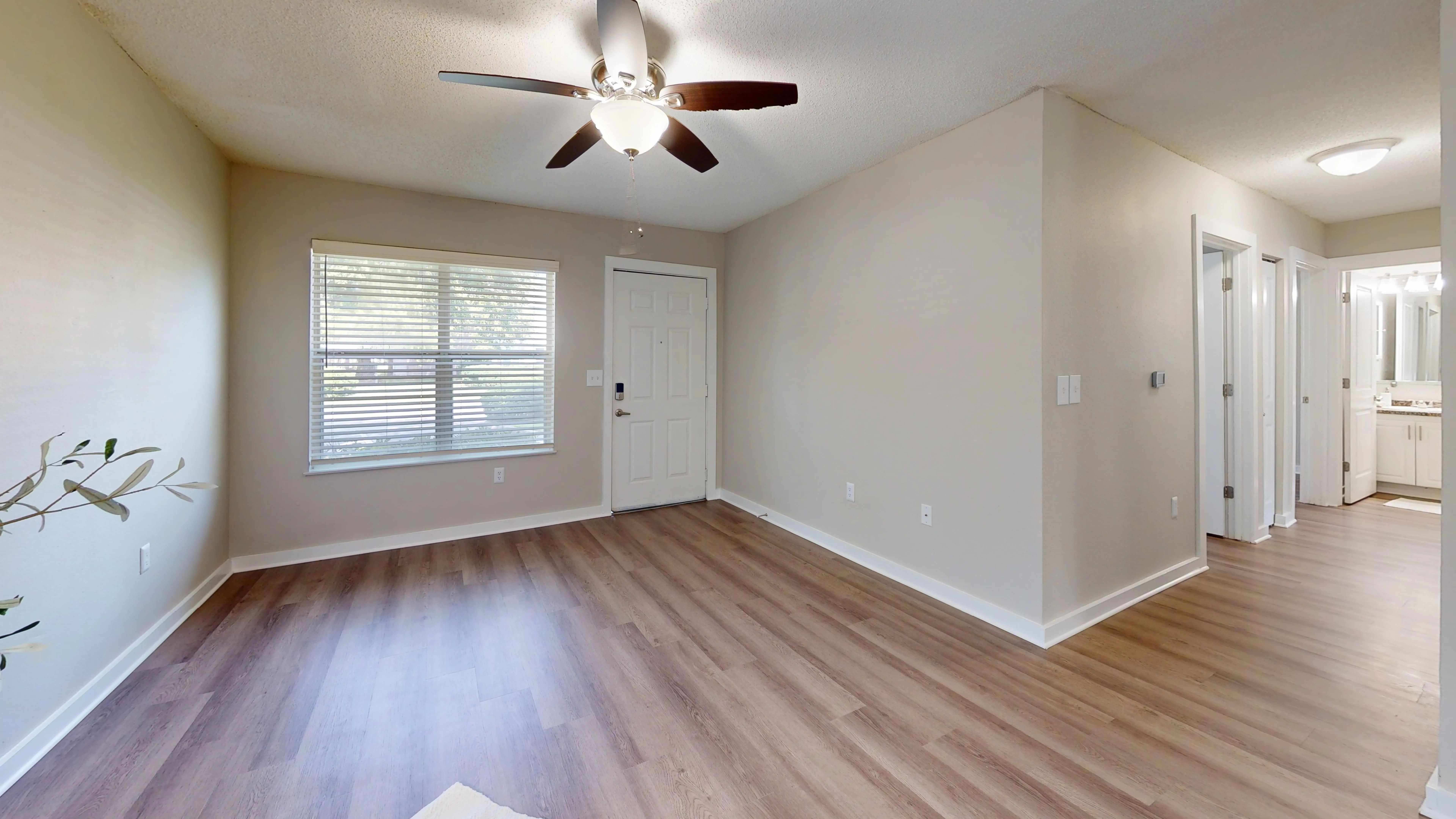 Unwind in this inviting living room space filled with natural light from a beautiful picture window, accompanied by a dedicated lighted ceiling fan for personalized comfort.
