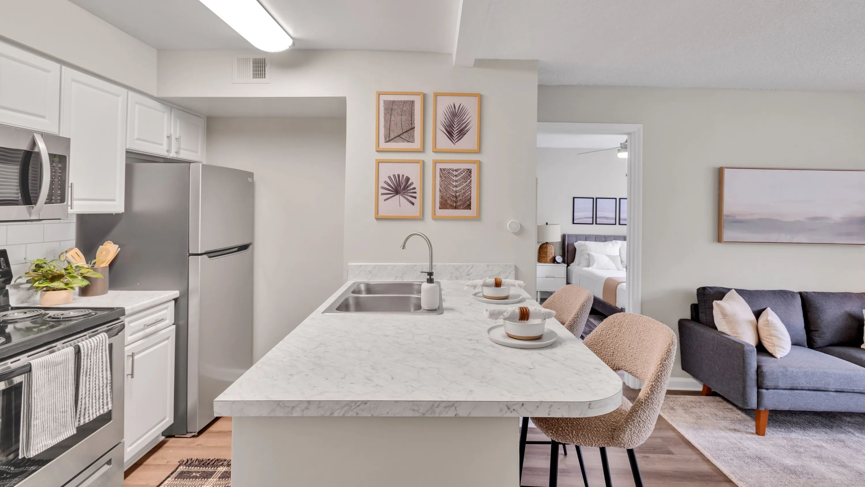 Our kitchens feature a seamless breakfast bar, with stunning white Carrara countertops, creating a bridge between the kitchen masterpiece and the inviting living space. 