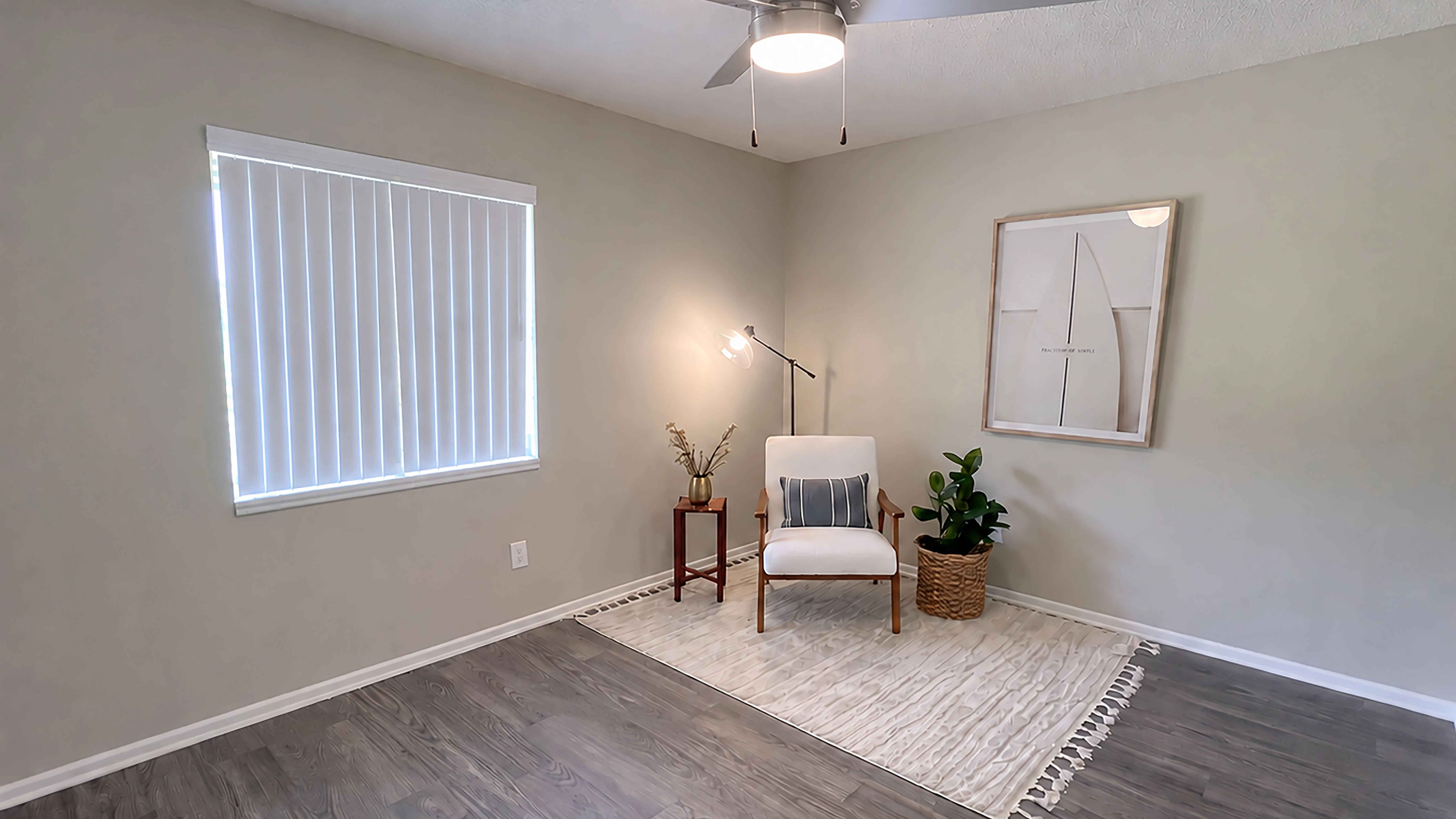 Make yourself at home in this spacious living room, featuring wood-style flooring, a ceiling fan, and a versatile layout with plenty of room to create a comfortable space that reflects your style.