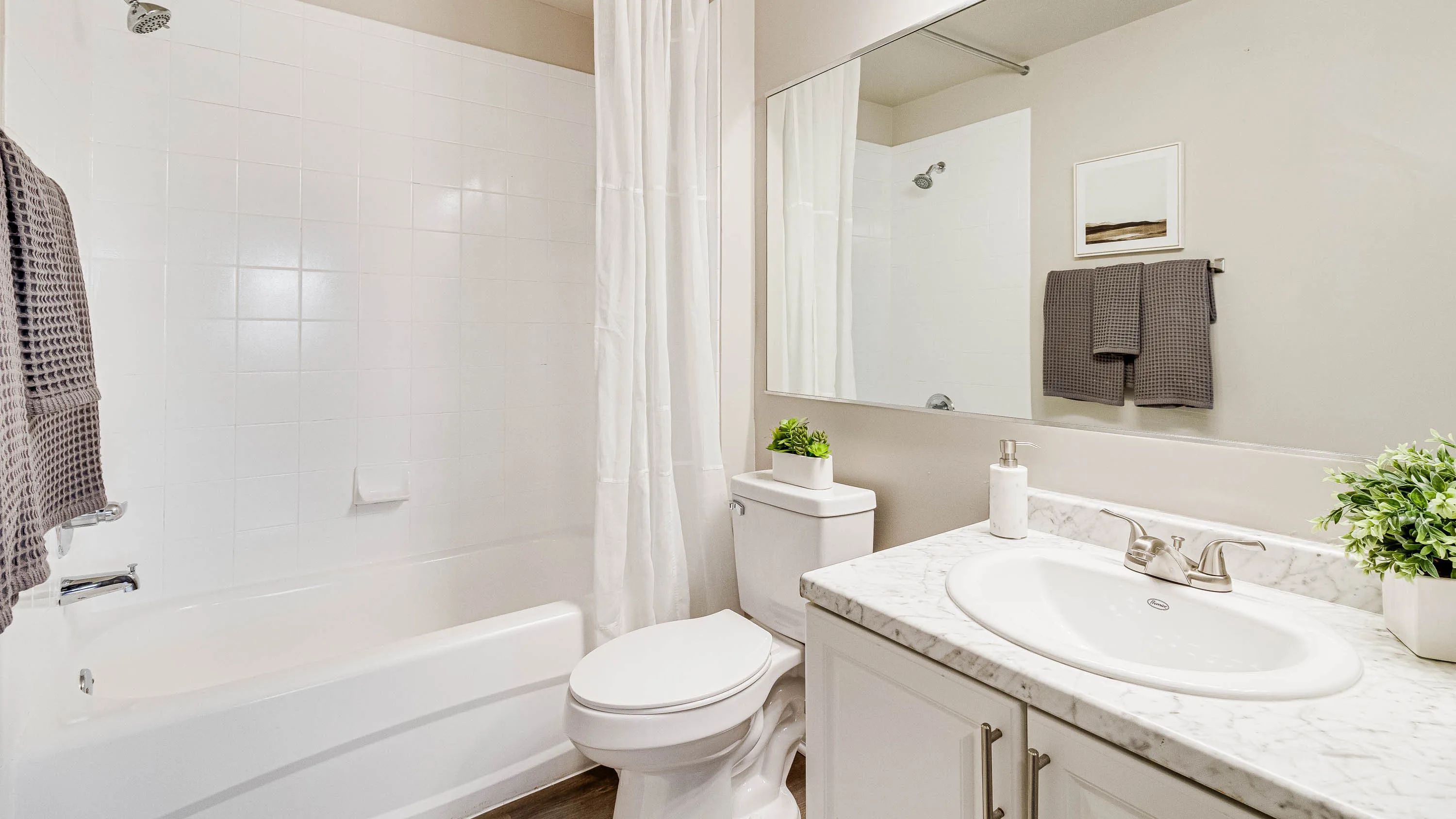 Spacious master bath boasting ample storage space and brilliant oversized mirrors.