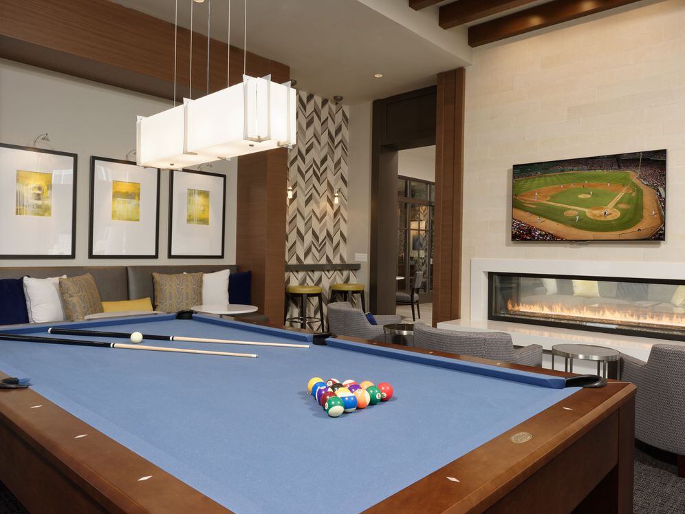 Resident lounge and game room with billiards and fireplace with seating