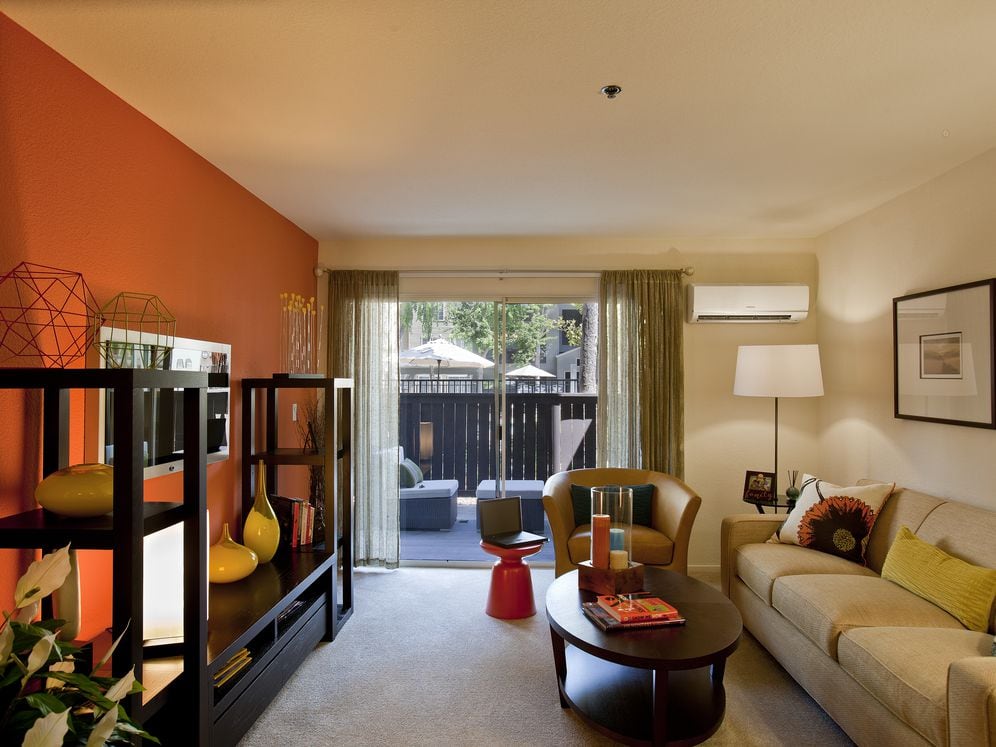 Living area with carpeted flooring, accent wall and patio access