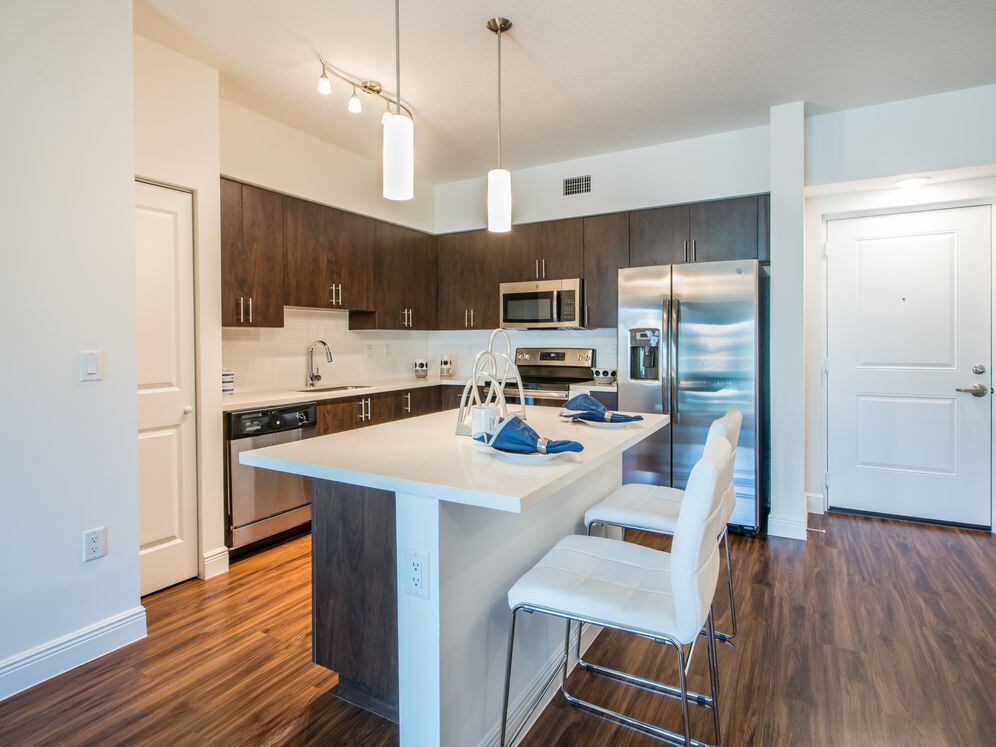 Kitchen with oak cabinetry, white countertops, white tile backsplash, and stainless steel appliances