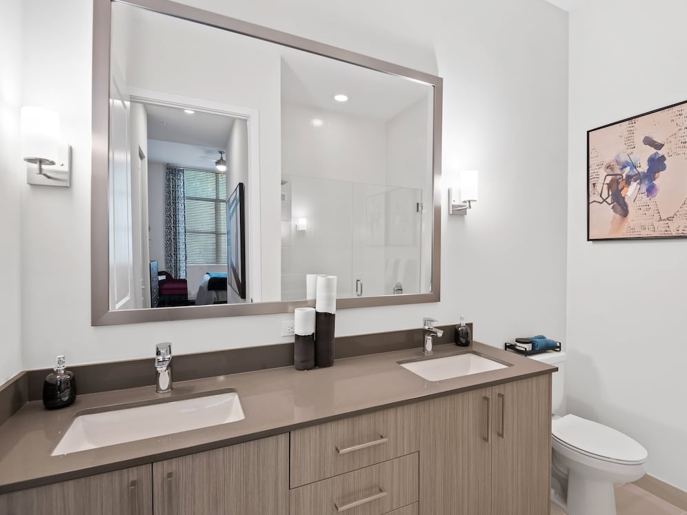Bath with dual sink vanity, grey quartz countertops and hard-surface vinyl plank flooring