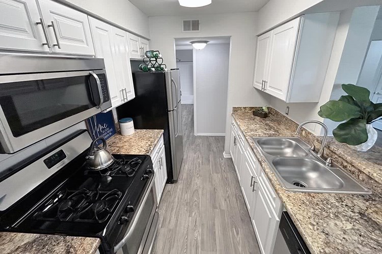 Our galley-style kitchens feature granite-style countertops, wood-style flooring, and a breakfast bar.