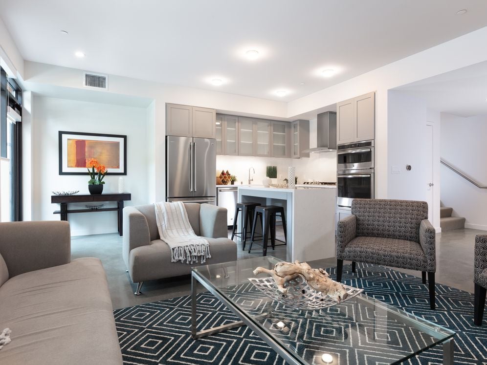 Signature Collection living and dining area with hard surface flooring and kitchen with stainless steel appliances