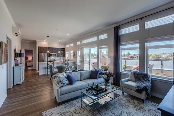 Our open living room and kitchen space includes a counter-level breakfast bar, large windows with ample natural light, and beautiful hard-wood style flooring. 