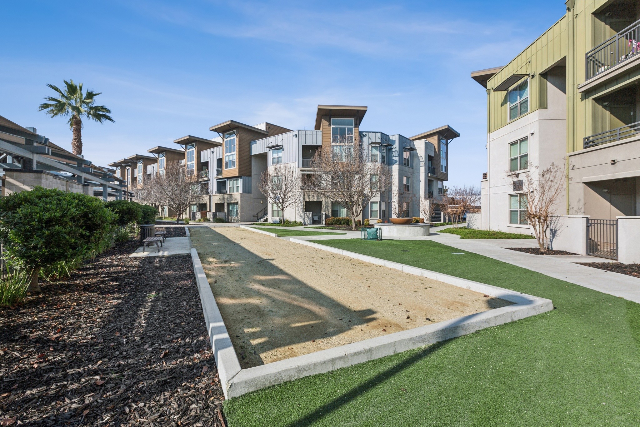 Aspire Apartments Tracy California Luxury Living Apartment complex with a fountain in the middle of a grassy area.