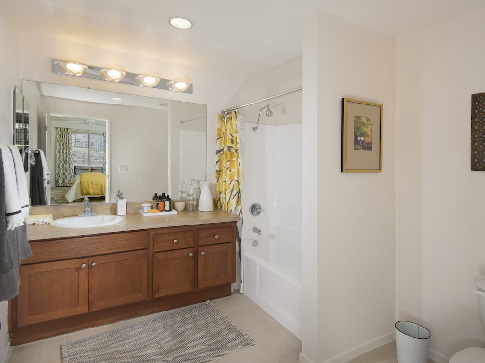 Classic Package I guest bath with maple cabinetry, beige speckled granite countertops, and tile flooring